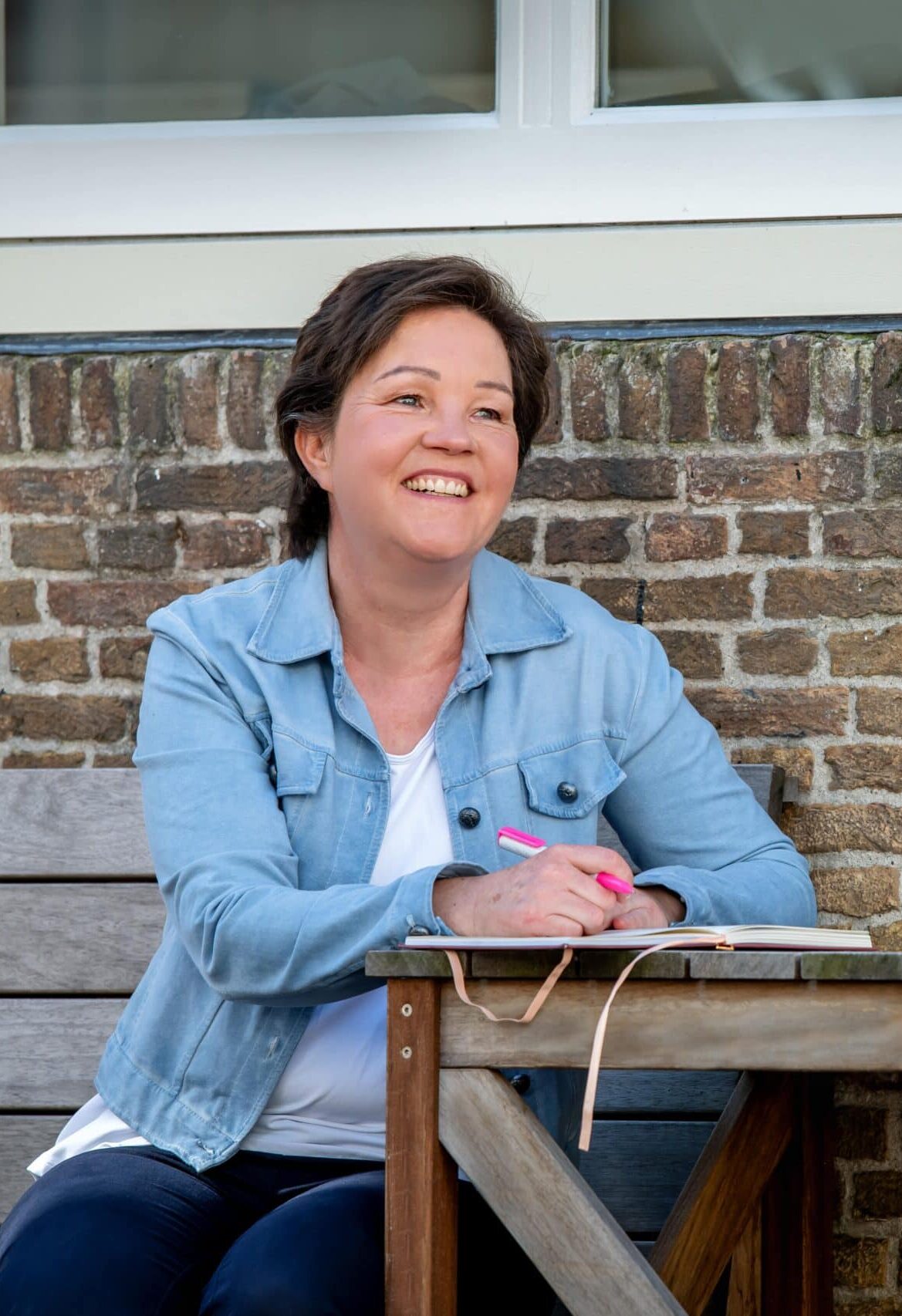 Liesbeth de Korte blauw jasje lezend aan tafel