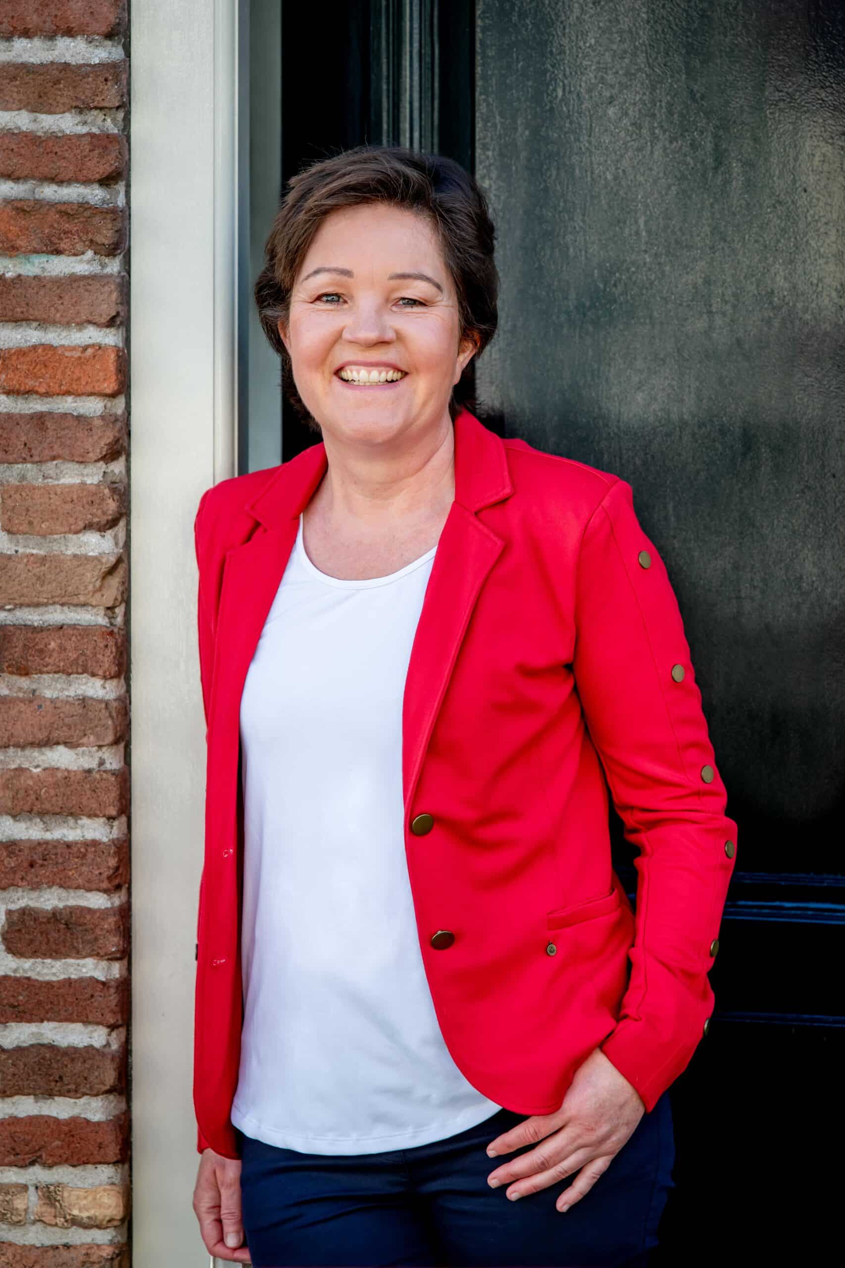 Liesbeth de Korte rood jasje portet voor deur close up